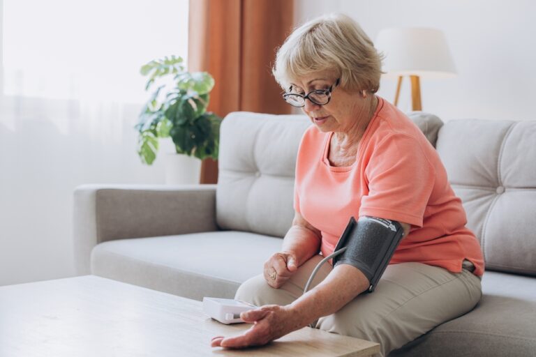 Senior woman with Hypertension, measuring her Blood Pressure at home.