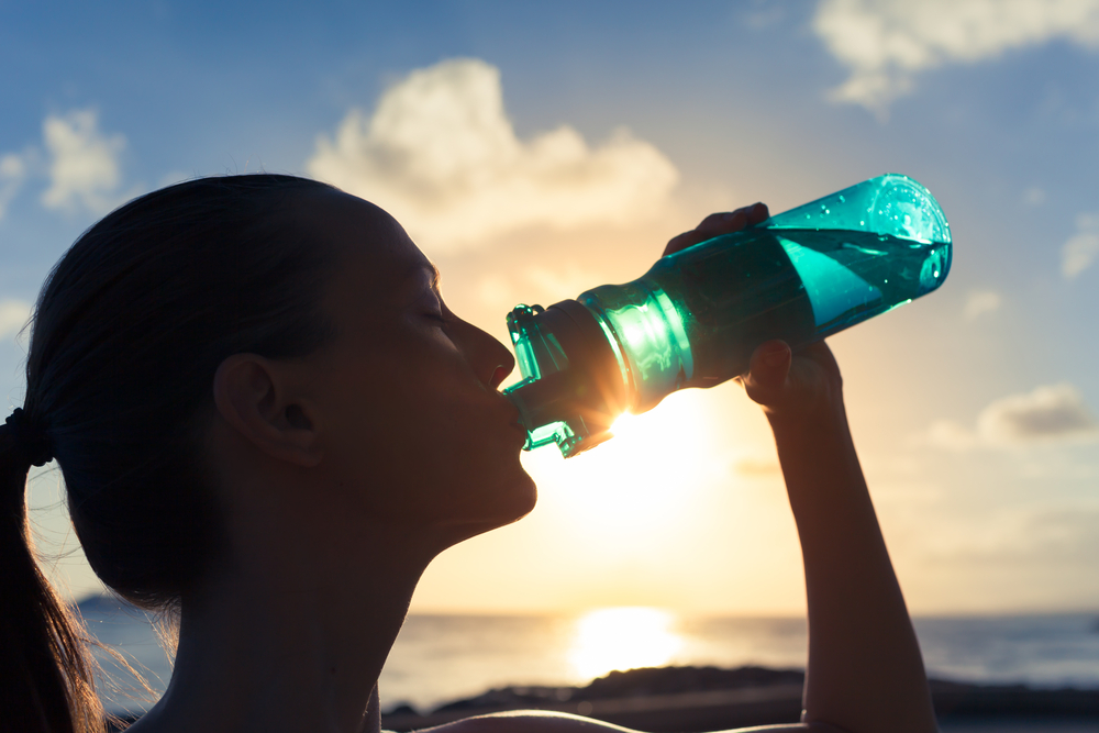 A woman drinking a bottle of water.